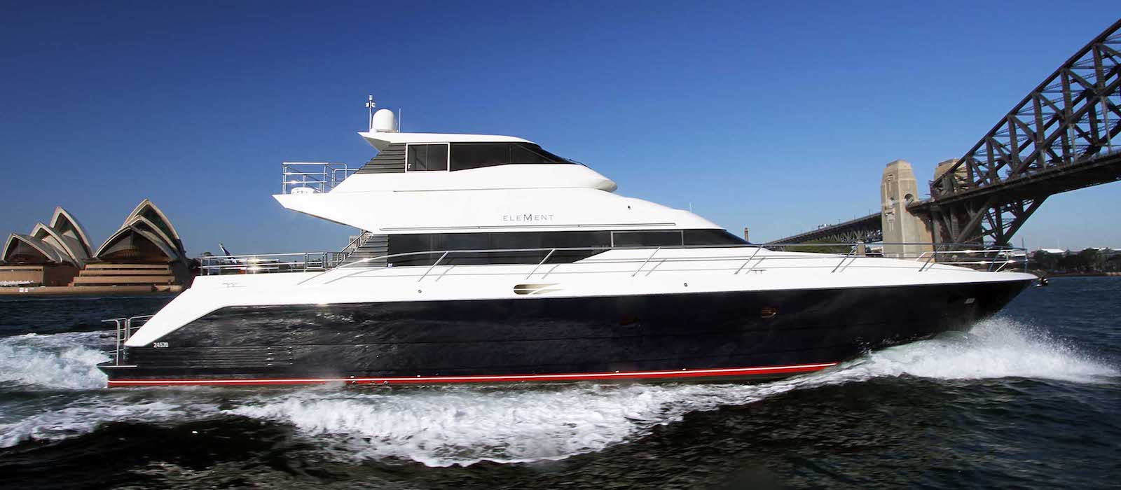 Side profile view of Element luxury charter yacht heading toward Harbour Bridge